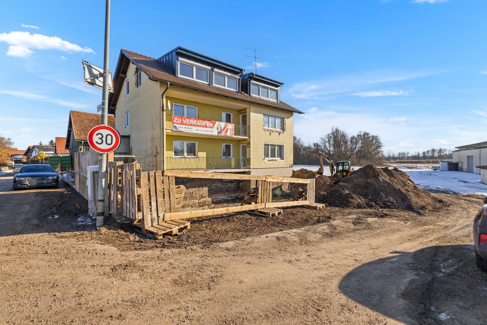 Außenansicht Baustelle mit Erdarbeiten und Bagger