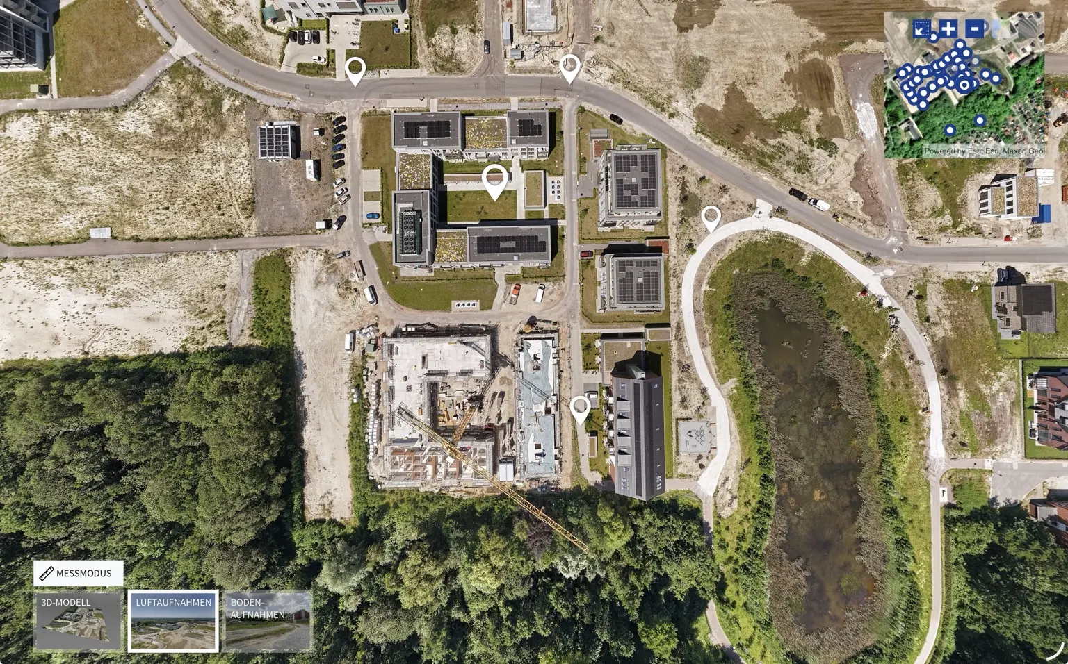 Senkrechte Luftaufnahme eines Stadtquartiers mit Gebäuden, Baustelle und Freiflächen