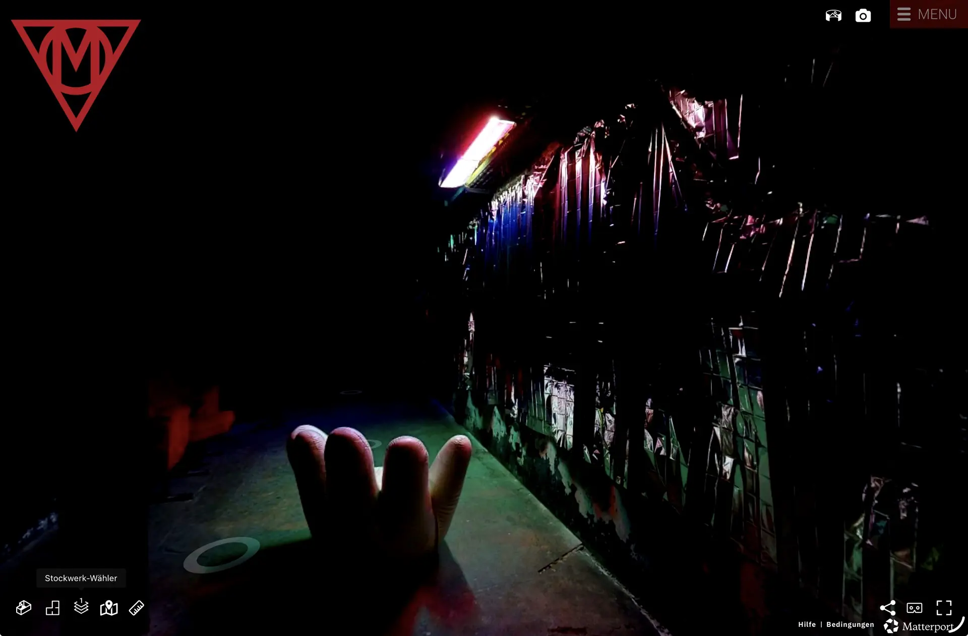Immersiver dunkler Installationsraum in der MaHalla mit farbigem Licht, reflektierenden Flächen und skulpturaler Sitzform