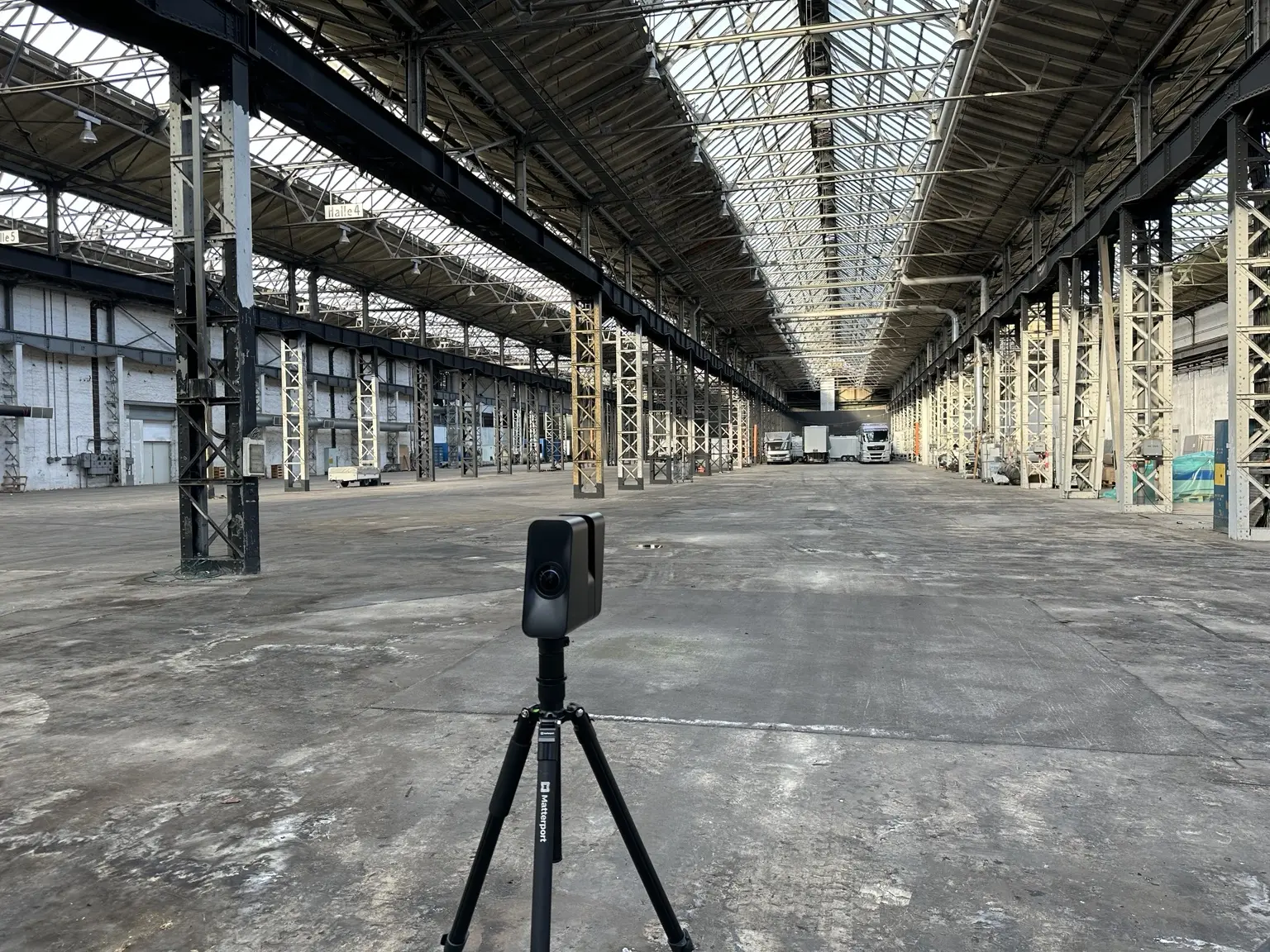 Mobiler 3D-Scanner im Zentrum der Industriehalle zwischen zahlreichen genieteten Stahlstützen.