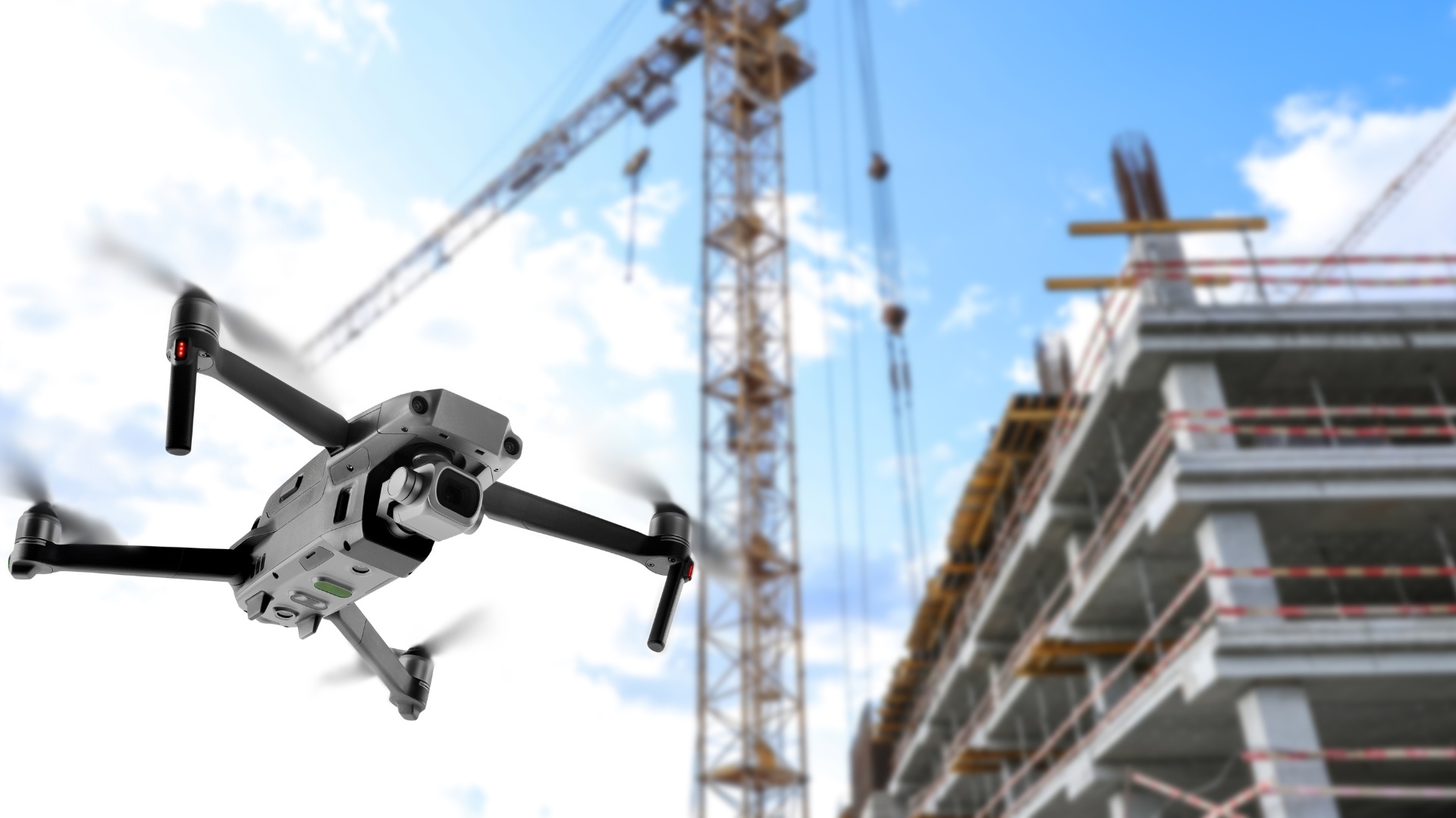 Drohne fliegt vor einer modernen Baustelle mit Kränen