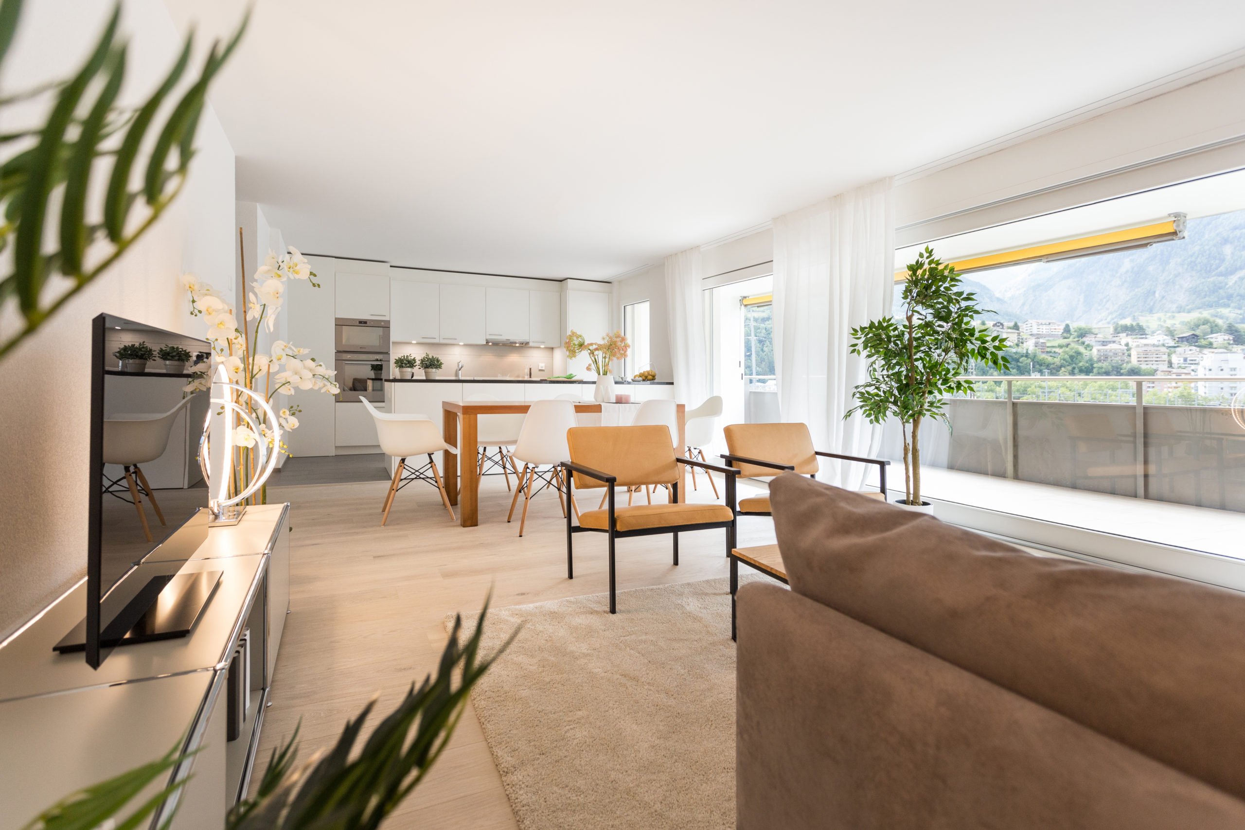Professionell fotografiertes, modernes Wohnzimmer mit offener Küche