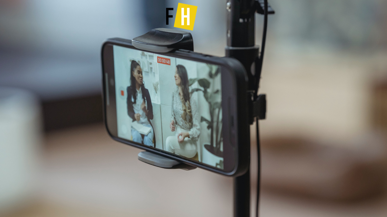 Zwei Personen erstellen ein Social-Media-Video mit einem Smartphone in einem Büro