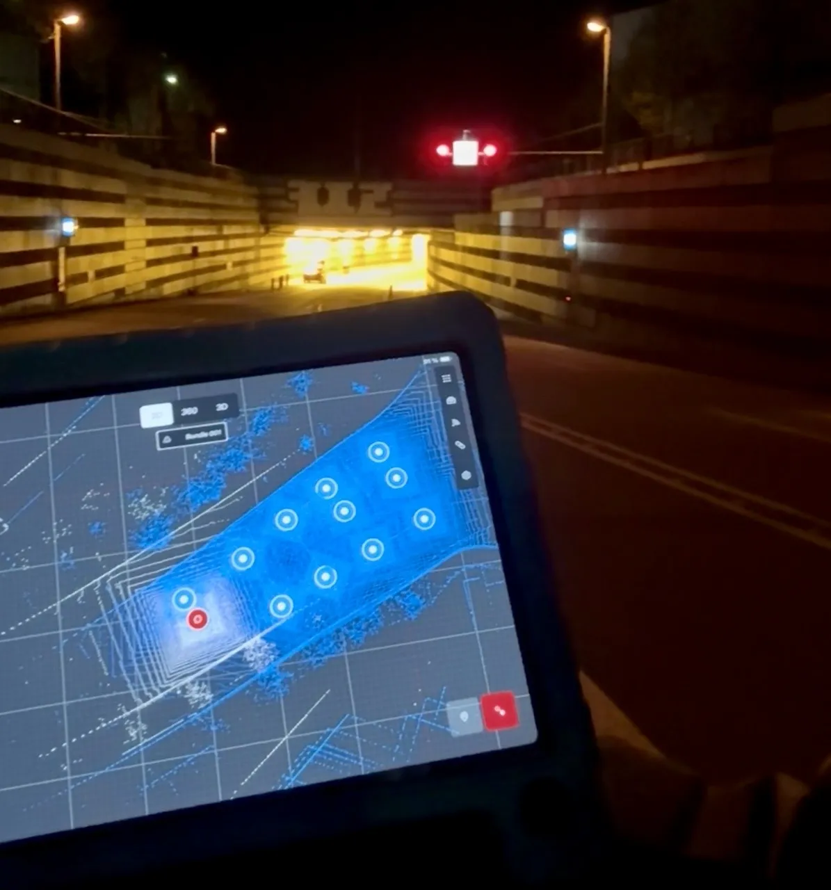 Tunnelvermessung vor Ort – Tablet mit Leica BLK360 Scan-Software vor einer Tunneleinfahrt bei Nacht