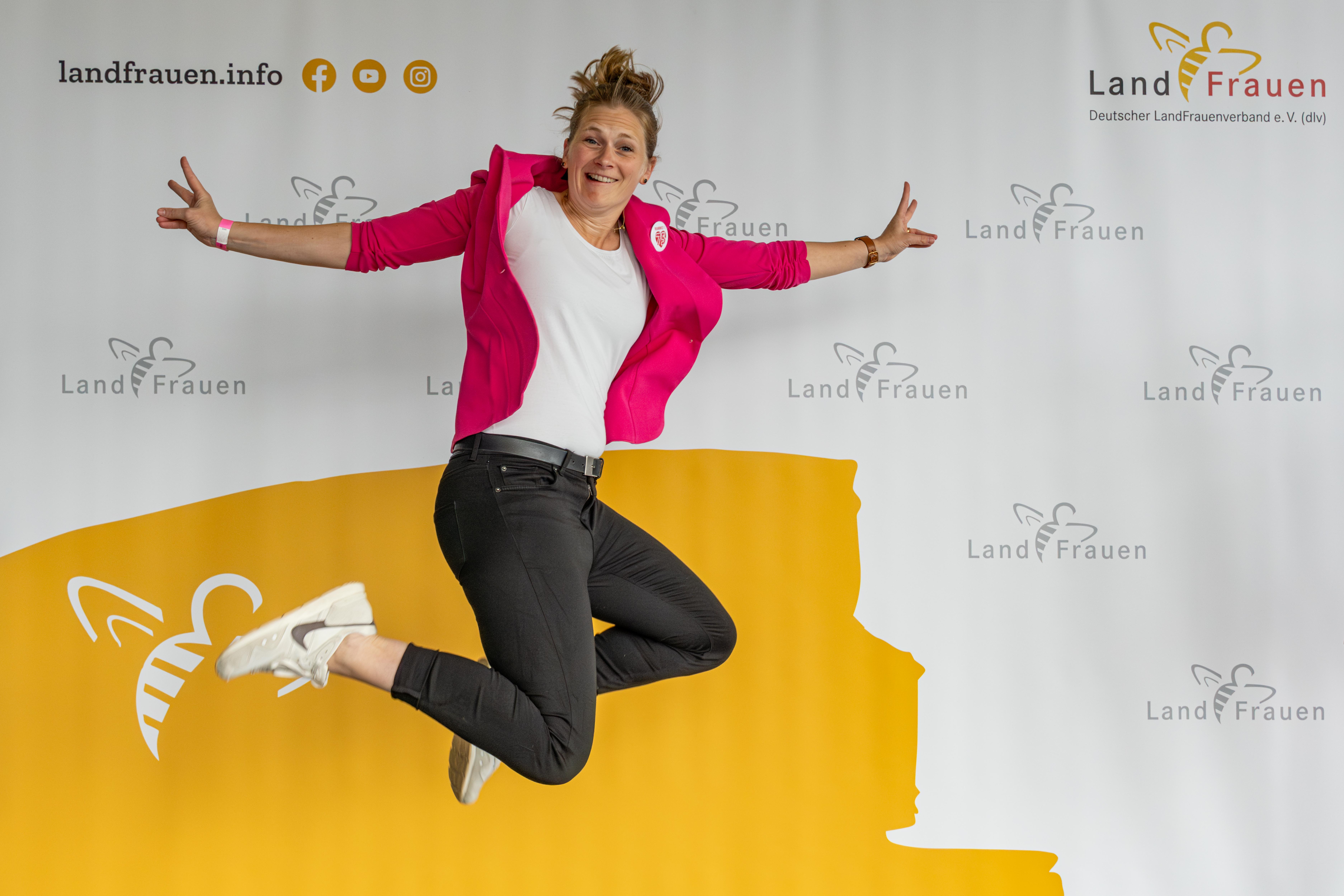 Springende Frau vor LandFrauen-Banner beim Deutschen Landfrauentag Kiel