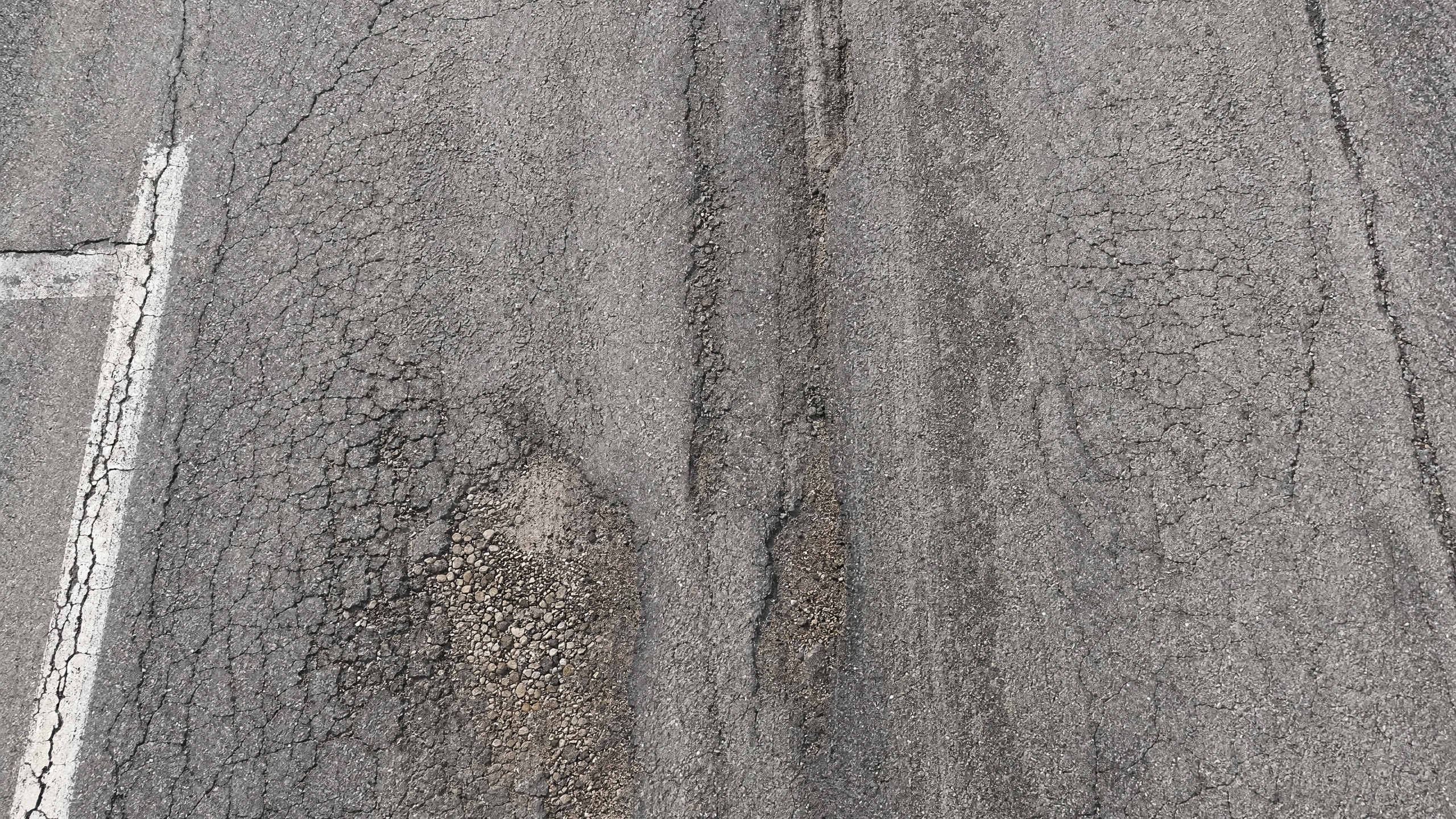 Detailaufnahme Straßenschäden – Netzrisse und Aufbrüche